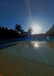 una piscina de agua con el sol en el cielo en APARTAMENTO SPAZZIO DI ROMA com acesso ao acqua park splash, en Caldas Novas