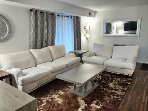 a living room with a white couch and a table at Charming Condo in Central Raleigh in Raleigh