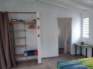 a room with a bed and a closet with a door at Le Gîte Petit colibri in Sainte-Rose