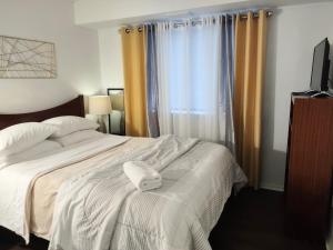 a bedroom with a bed with two towels on it at Desirable Condo in Central Raleigh in Raleigh