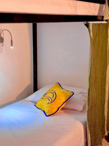 cuscino giallo seduto sopra un letto di Hostel Al-Qurtubi a Tangeri