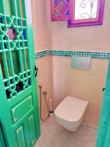 a bathroom with a toilet and a green door at Hostel Al-Qurtubi in Tangier