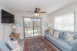 - un salon avec un canapé bleu et un ventilateur de plafond dans l'établissement Ocean Village Club N23, à Saint Augustine