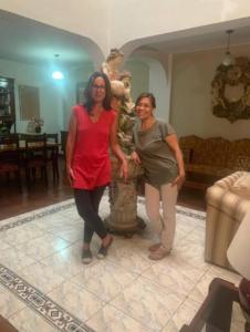 zwei Frauen stehen neben einer Statue in einem Raum in der Unterkunft Habitación en Primer Piso con baño privado in Lima