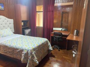 ein Hotelzimmer mit einem Bett, einem Schreibtisch und einem Schreibtisch in der Unterkunft Habitación en Primer Piso con baño privado in Lima