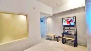 Zimmer mit einem großen Spiegel und einem TV in der Unterkunft Votel Hotel Charis Tuban in Jembel