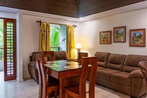 a living room with a table and a couch at Laguna Eco Village #205 Pool/ Tennis Courts/ BBQ in Quepos