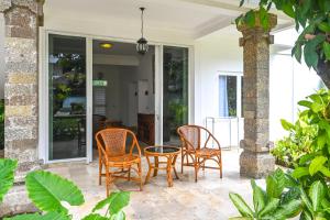 um grupo de cadeiras e uma mesa num pátio em Hotel Sari Bunga em Legian