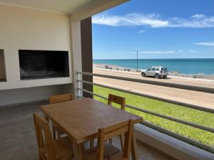 jadalnia ze stołem i widokiem na plażę w obiekcie Departamento Frente Al Mar Excelente Vista Y Comodidad Las Grutas w mieście Las Grutas