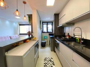 eine Küche mit Spüle und Arbeitsplatte in der Unterkunft Apto central e próximo à praia in Torres + 8 Fotos