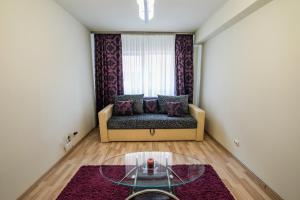 un soggiorno con divano e tavolo in vetro di Quiet 3-Room Apt - 2 Parking Spaces - 5 Min Bus a Floreşti