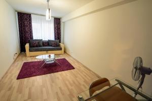 a living room with a couch and a table at Quiet 3-Room Apt - 2 Parking Spaces - 5 Min Bus in Floreşti