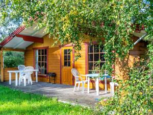 een hut met een tafel en stoelen op een patio bij Holiday home Farsø IX in Farsø