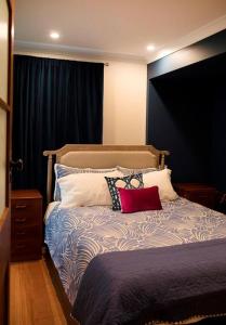 Un dormitorio con una cama con almohadas encima. en Caradi Apartment - inner city retreat, en Kings Park
