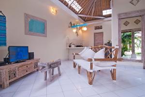a living room with a tv and a couch at Villa Domus Dua in Seminyak
