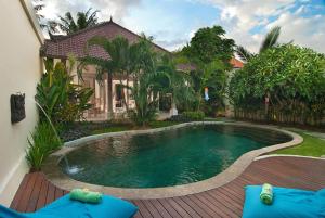 a swimming pool in front of a house at Villa Domus Dua in Seminyak