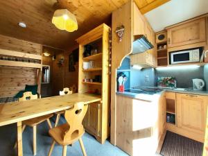 a kitchen with a wooden table in a cabin at Studio La Plagne, 1 pièce, 3 personnes - FR-1-351-23 in La Plagne