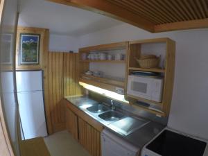 a small kitchen with a sink and a refrigerator at Appartement lumineux 60m² · 2 ch. · Balcon · WIFI · Parking - FR-1-346-557 in Arc 1800