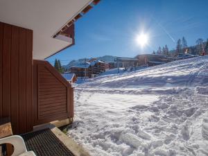 une piste de ski enneigée avec le soleil en arrière-plan dans l'établissement Appartement Morillon Village, 3 pièces, 7 personnes - FR-1-642-84, à Morillon