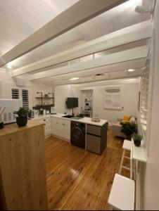 a large kitchen with white walls and wooden floors at The Stables in Armidale