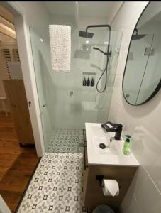 een badkamer met een wastafel en een douche met een spiegel bij The Stables in Armidale