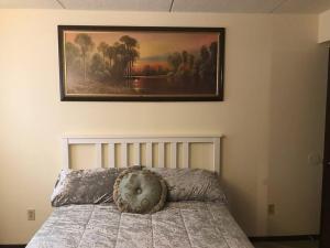 een slaapkamer met een bed met een foto aan de muur bij Cozy private getaway. Close to Convention Center and Medical Centers in Monroeville