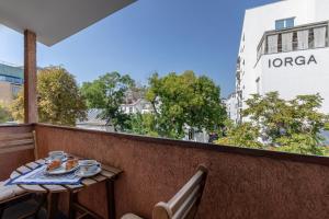 une table avec une assiette de nourriture sur un balcon dans l'établissement HOLT - Dolce in Napoli, à Bucarest