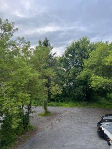 a car parked in a parking lot next to trees at Le St-Augustin in Mirabel