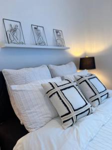uma cama branca com quatro almofadas em cima em Le St-Augustin em Mirabel