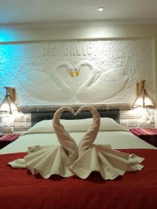 Dos cisnes hechos de toallas en una cama en Hotel REY DAVID en Uyuni