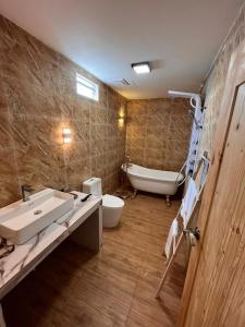 a bathroom with a sink and a tub and a toilet at Villa Bari Loft in Setiu