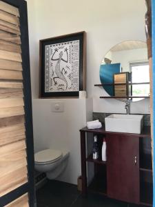 a bathroom with a toilet and a sink and a mirror at La Suite Vue Lagon in Uturoa