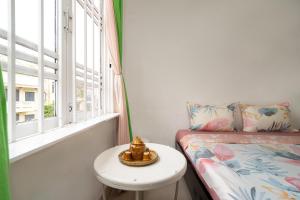 a small room with a bed and a table and a window at HY Local Budget Hotel by Hoianese - 5 mins walk to Hoi An Ancient Town in Hoi An
