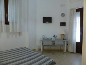 サン・テレンツォにあるAffittacamere Il Pellegrinoのベッドルーム(テーブル、椅子2脚、テレビ付)
