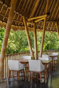 チャングーにあるTheanna Villa and Spa Cangguの藁傘下のテーブルと椅子