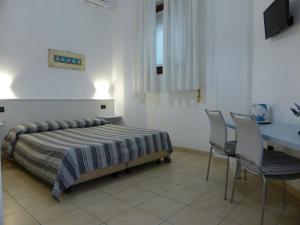 sypialnia z łóżkiem, stołem i krzesłami w obiekcie Affittacamere Il Pellegrino w mieście San Terenzo