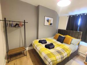 Schlafzimmer mit einem Bett mit gelben und blauen Kissen in der Unterkunft Sigma Crown - Free Street Parking 