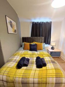 a yellow bed with two pairs of towels on it at Sigma Crown - Free Street Parking 