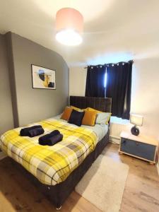 ein Schlafzimmer mit einem Bett mit einer gelben Decke in der Unterkunft Sigma Crown - Free Street Parking 