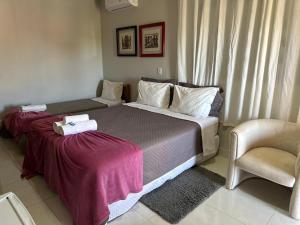 沙帕達－杜斯吉馬朗伊斯的住宿－Pousada Luar，一间卧室配有一张大床和一把椅子