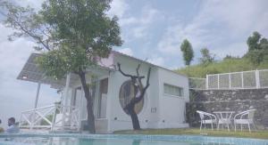 uma casa com uma estátua ao lado de uma piscina em The Bohemian Casa Dehradun em Dehradun