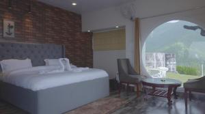 1 dormitorio con cama, mesa y ventana en The Bohemian Casa Dehradun en Dehradun
