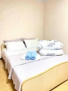 1 dormitorio con 1 cama con toallas en Town House, metro Raiymbek, en Almaty