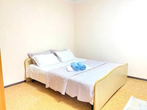 um quarto com uma cama com duas toalhas azuis em Town House, metro Raiymbek em Almaty