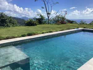 a swimming pool with a view of the ocean at La Suite Vue Lagon in Uturoa