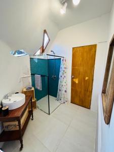 a bathroom with a sink and a wooden door at Cuchilla Alta domo geodésico in Cuchilla Alta