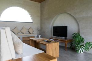 a living room with a tv and a couch at Mandevilla Canggu in Canggu