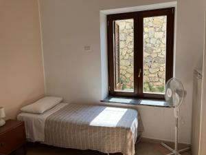 Habitación pequeña con cama y ventana en Casa Alzira, en San Lazzaro Agerola