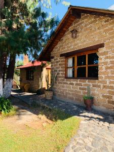 a brick house with a window on the side of it at Cabañas Los Cactus in San Miguel Regla