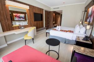um grande quarto de hotel com uma cama e uma secretária em Mandarin Bay Resort and Spa em Boracay